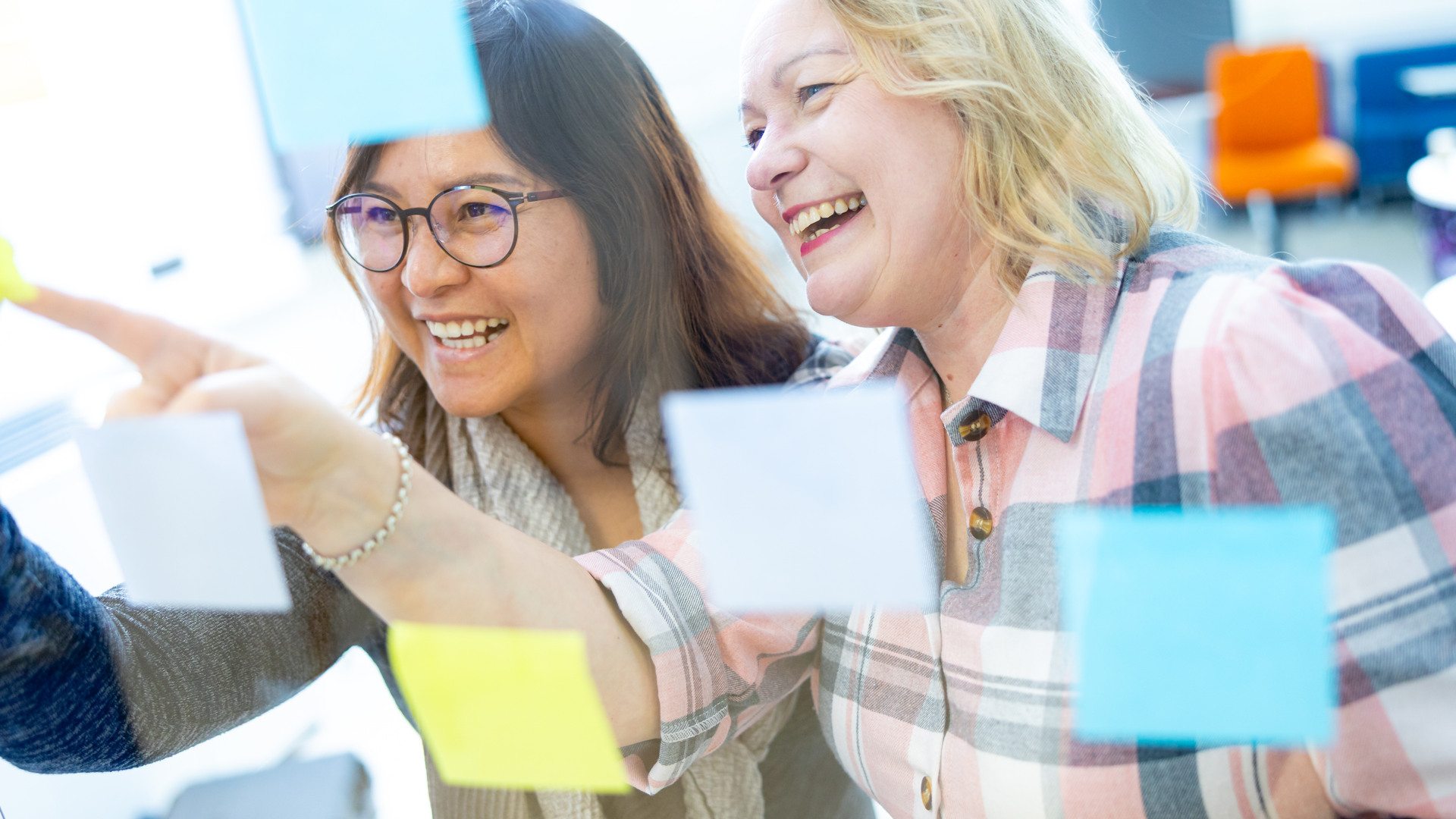 Anne Liimatainen opiskelee post-it lappujen avulla luokan lasin takana.