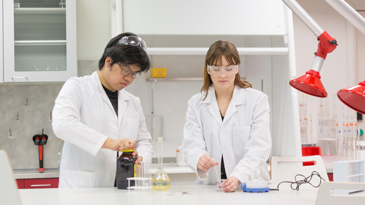 Opiskelijat kemian laboratoriossa