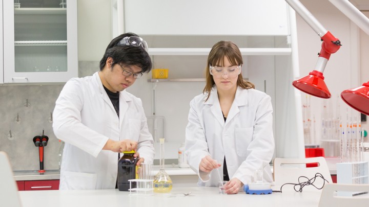 Opiskelijat kemian laboratoriossa