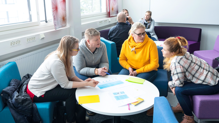 Opiskelijat työskentelevät yhdessä pöydän ääressä