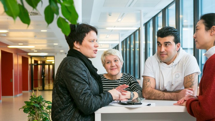 Kuvituskuva ihmiset keskustelevat pöydän ääressä