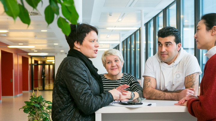 Kuvituskuva ihmiset keskustelevat pöydän ääressä