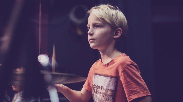 Nuori musiikin perusopetuksen oppilas soittaa rumpuja.