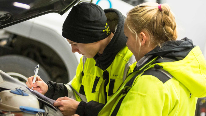 Autualan opiskelijat tutkivat autoa konepellin alta.