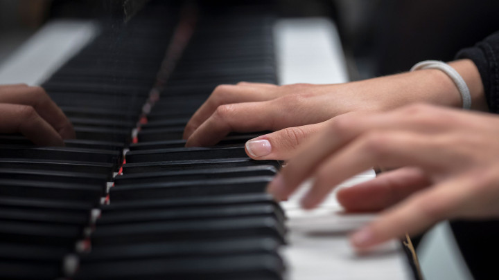 Kädet soittamassa pianoa.