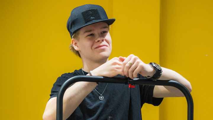 Nuori opiskelijapoika hymyilee tyytyväisenä.