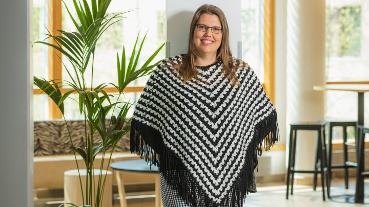 Kirjoittaja Gradian aulatiloissa seisomassa, katse kameraan.