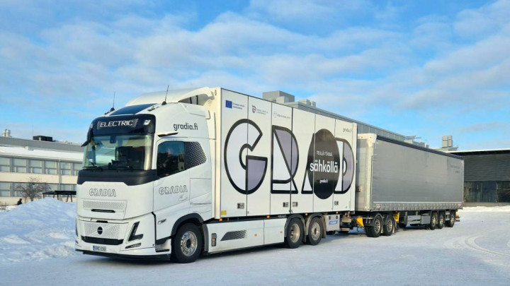 Sähköinen yhdistelmäajoneuvo kampuksen piha-alueella kirkkaana talvipäivänä.