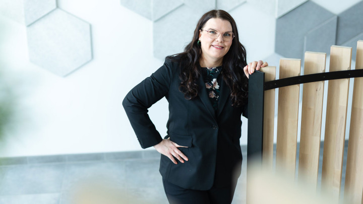 Henkilö Gradian toimitiloissa kuvattuna katsoo kameraan.