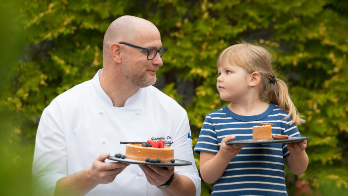 Mies ja tyttö kakkulautasten kanssa